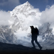 Man walking in front of the white snow capped mountain Fish-tail.